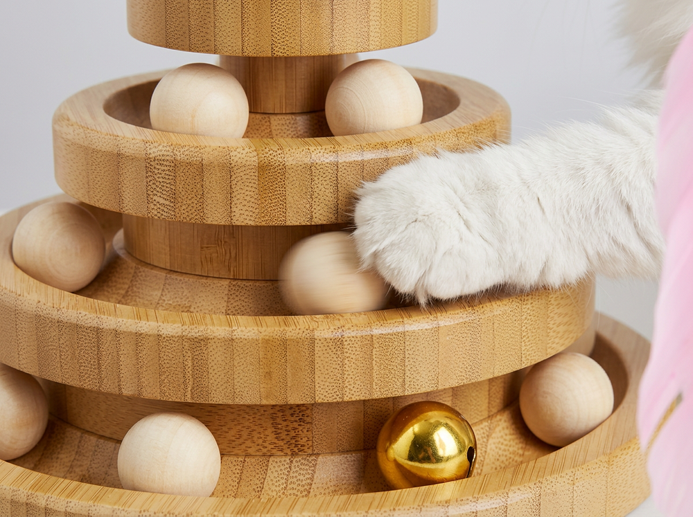 Wooden cat toy with rolling ball tracks on multiple levels.
