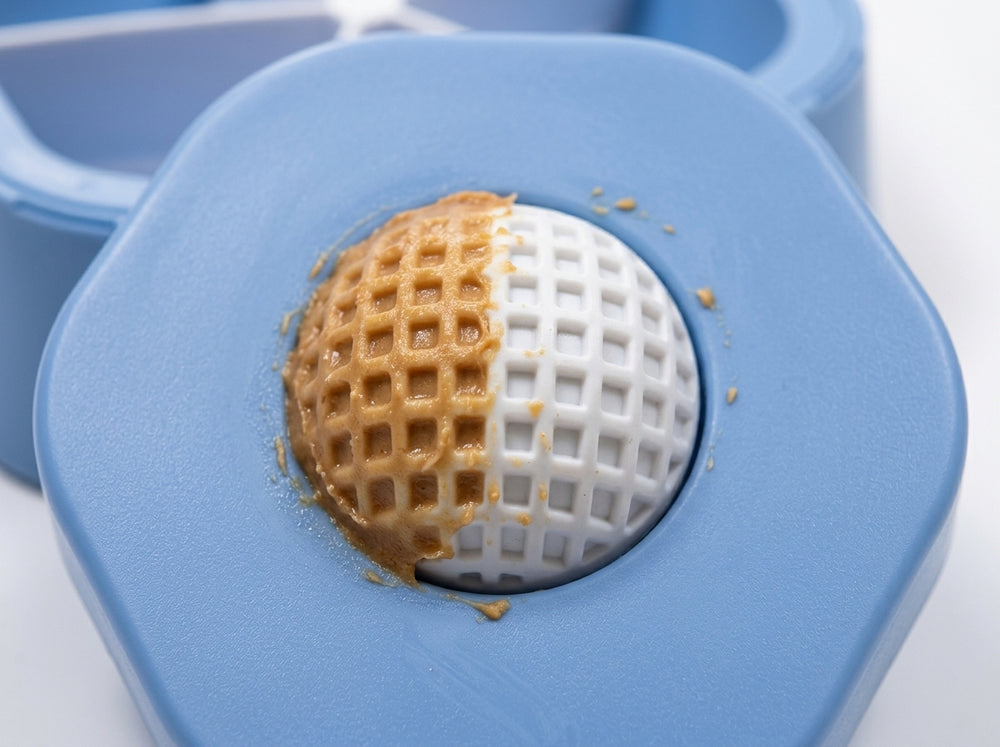 Close-up of white textured licking ball on blue dog feeder lid